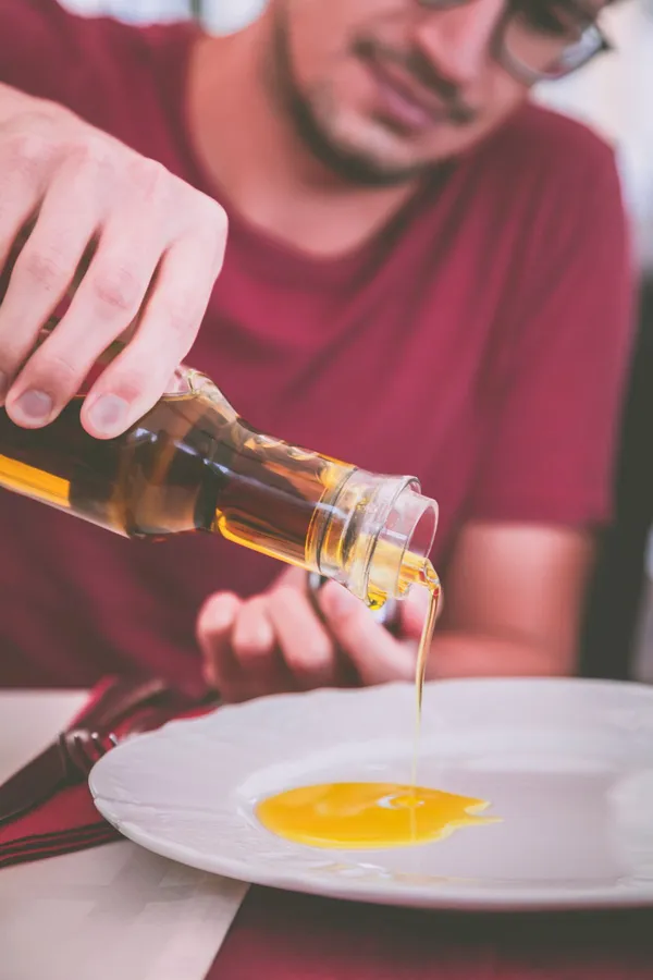 Canola oil being poured onto a plate